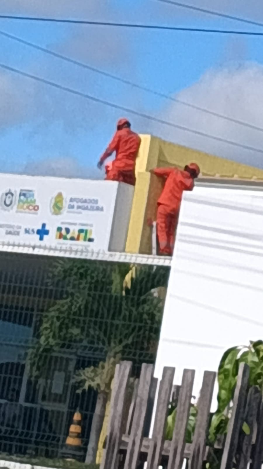 Bombeiros tirando a vítima do telhado do CER